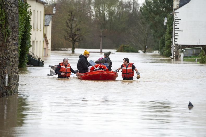 Elementos de cuadrillas de rescate sacan a pobladores atrapados en sus viviendas en un pequeño bote luego que la tormenta Herminia causó aguaceros en la región, el lunes 27 de enero de 2025 en la aldea de Guipry Messac, en el oeste de Francia. (AP Foto/Str)