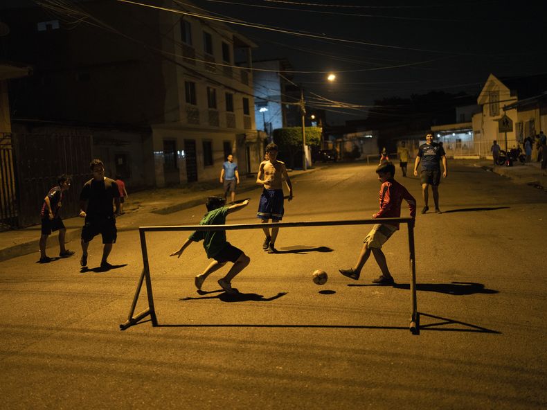 Varios jóvenes juegan al fútbol en la ciudad de Durán, ubicada frente a Guayaquil, Ecuador, el 30 de septiembre de 2023. (AP Foto/Rodrigo Abd)