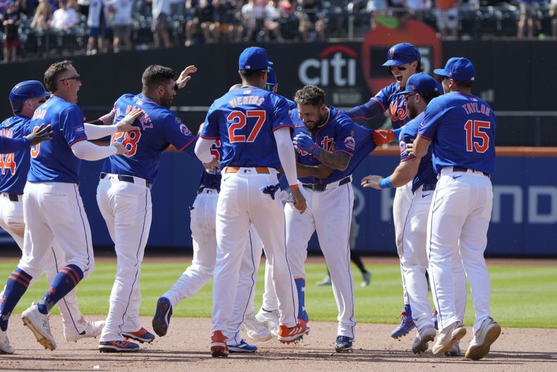 Omar Narváez (2), cuarto desde la derecha, celebra con sus compañeros de equipo después de batear sencillo para dejar tendidos a los Gigantes de San Francisco en la novena entrada del juego de béisbol del domingo 26 de mayo de 2024, en el Citi Field, en Nueva York. (AP Foto/Seth Wenig)