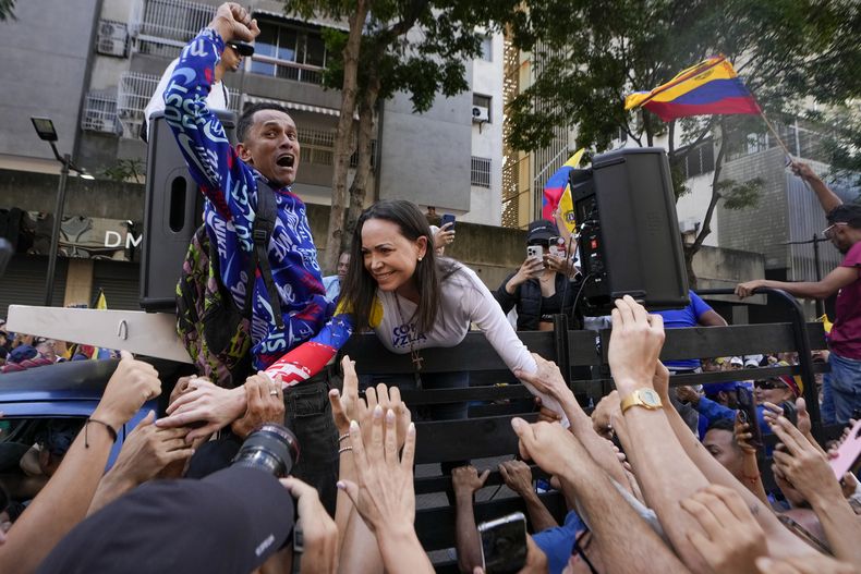 La líder de la oposición María Corina Machado saluda a sus partidarios durante una protesta contra el presidente venezolano Nicolás Maduro, el día antes de su toma de posesión para un tercer mandato en Caracas, Venezuela, el jueves 9 de enero de 2025. (AP Foto/Matías Delacroix)