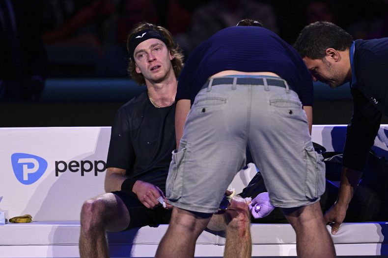 Andrey Rublev recibe atención médica tras lesionarse la rodilla con la raqueta por frustración durante la derrota ante el español Carlos Alcaraz en las Finales de la ATP el miércoles 15 de noviembre del 2023. (Marco Alpozzi/LaPresse via AP)
