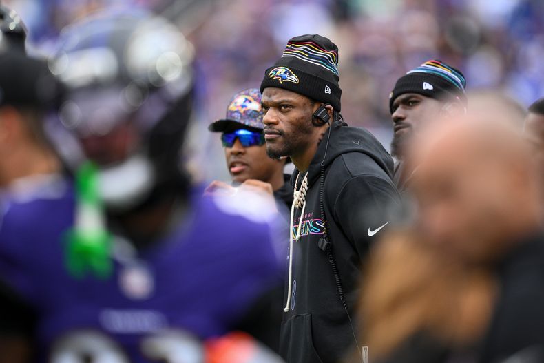 Lamar Jackson, quarterback de los Ravens de Baltimore, observa desde la banca el desarrollo del partido durante la primera mitad del partido de la NFL contra los Rams de Los Ángeles, el domingo 12 de octubre de 2025, en Baltimore. (AP Foto/Nick Wass)