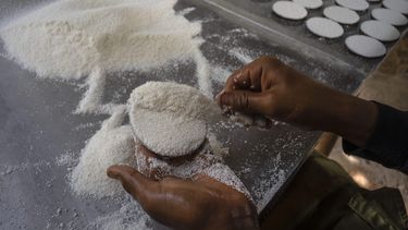 El productor de casabe Eriel Núnez da forma de tortilla al casabe con un molde de forma redonda, en Quivicán, Cuba, el lunes 28 de mayo de 2023. Casabe, una tortilla hecha de yuca, también conocida como cassava, es uno de los alimentos de origen indígena más antiguos de Cuba. (AP Foto/Ramón Espinosa)