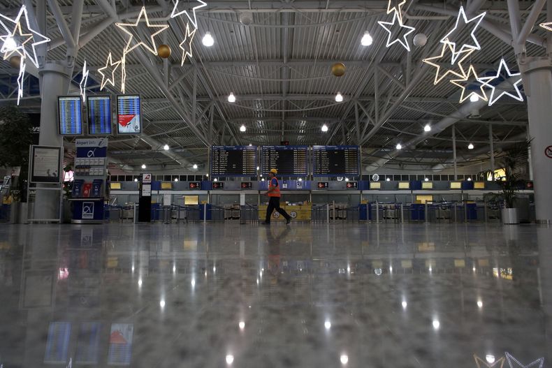 Un empelado pasa por delante de mostradores de facturaci&oacute;n vac&iacute;os durante una huelga general nacional de 24 horas, en el aeropuerto Eleftherios Venizelos en Spata, cerca de Atenas, el 27 de noviembre de 2014. (Foto AP/Kostas Tsironis)