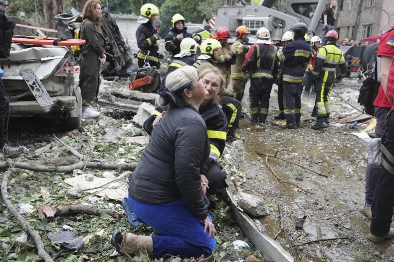 Una trabajadora de emergencias consuela a una mujer que llora en el lugar donde un misil ruso cayó durante la noche, en Kiev, Ucrania, el jueves 31 de julio de 2025. (AP Foto/Efrem Lukatsky)