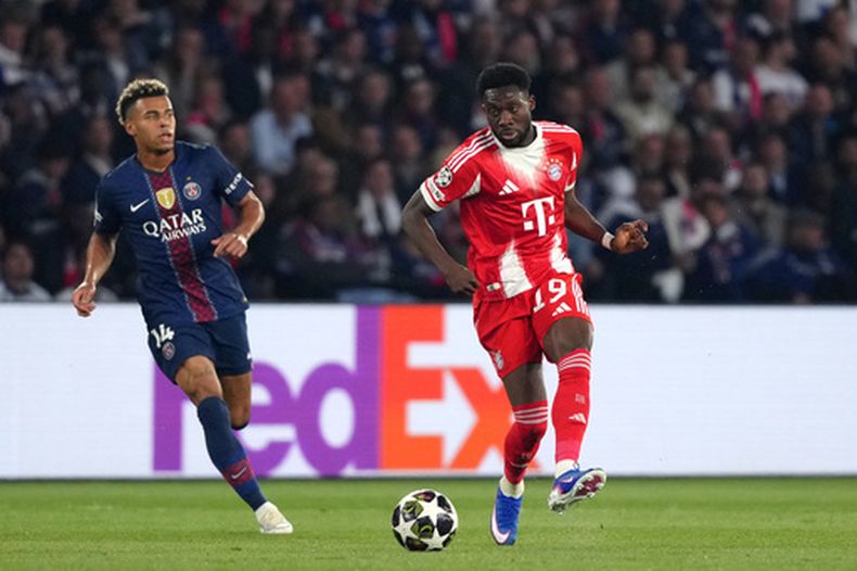 Alphonso Davies (derecha) del Bayern Múnich lanza un pase ante Desire Doue del Paris Saint-Germain en el partido de ida de las semifinales de la Liga de Campeones, el martes 28 de abril de 2026, en París. (AP Foto/Aurelien Morissard)