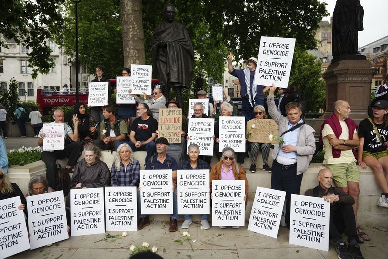 Varias personas participan en una protesta de apoyo al grupo Palestine Action, organizada por el grupo Defend Our Juries (Defendamos a nuestros jurados), frente a la estatua de Mahatma Gandhi en la Plaza del Parlamento, en Londres, Inglaterra, el sábado 5 de julio de 2025. (Jeff Moore/PA vía AP)