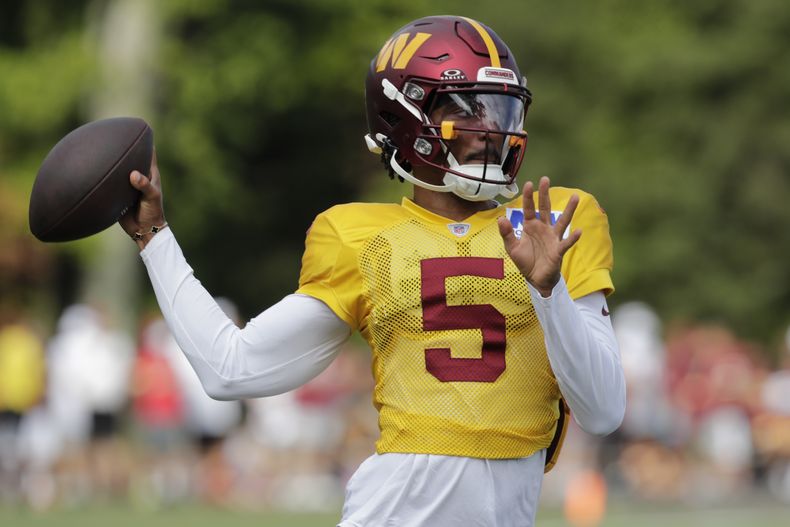 El mariscal de campo de los Washington Commanders, Jayden Daniels, lanza el balón durante una práctica de fútbol americano de la NFL en las instalaciones de entrenamiento del equipo en Ashburn, Virginia, el domingo 4 de agosto de 2024. (AP Foto/Luis M. Álvarez)