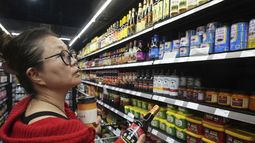 La chef Miki Fujiwara compra salsa de soja Pearl River de China en 99 Ranch Market, una tienda de comestibles asiática en Los Ángeles, el lunes 7 de abril de 2025. (AP Foto/Damian Dovarganes)