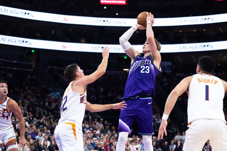 Lauri Markkanen (23). del Jazz de Utah, dispara sobre Collin Gillespie (12), de los Suns de Phoenix, durante la segunda mitad del partido de baloncesto de la NBA, el lunes 27 de octubre de 2025, en Salt Lake City. (AP Foto/Anna Fuder)