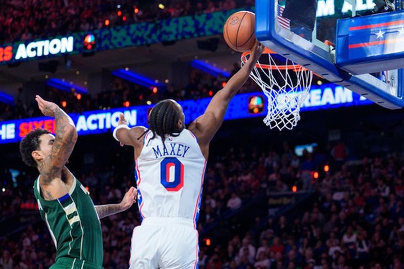 El jugador de los 76ers de Filadelfia, Tyrese Maxey, a la derecha, se eleva para hacer un tiro contra Kyle Kuzma, de los Bucks de Milwaukee, a la izquierda, durante la primera mitad de un partido de básquetbol de la NBA, el sábado 24 de octubre de 2026, en Filadelfia. (Foto AP/Chris Szagola)