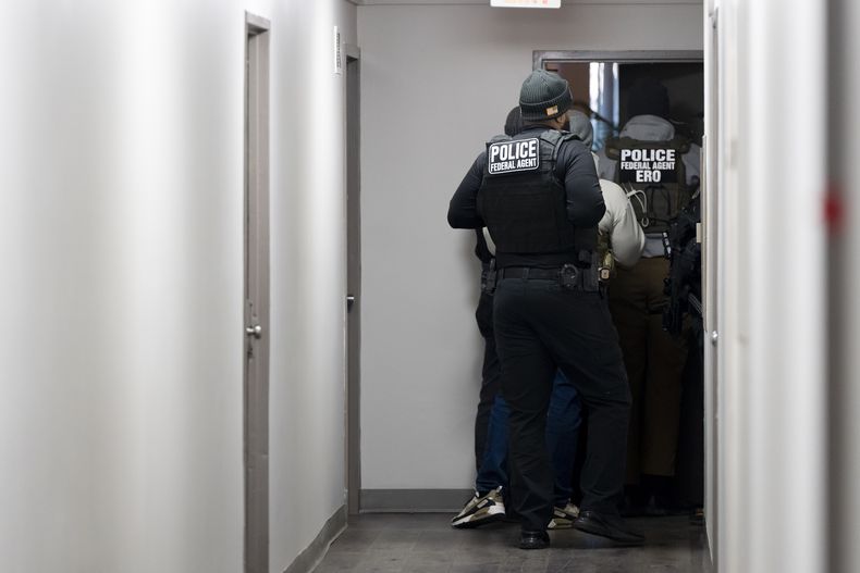 Agentes del Servicio de Control de Inmigración y Aduanas (ICE, por sus siglas en inglés) entran en una vivienda buscando a un sospechoso, el lunes 27 de enero de 2205 en Takoma Park, Maryland. (AP Foto/Alex Brandon)