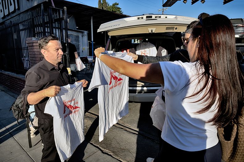 Un fan mide camisetas durante un evento emergente de productos de la película Anora el sábado 9 de noviembre de 2024 en Los Ángeles. (Foto AP/Richard Vogel)