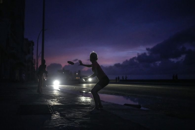 Una mujer se prepara para atrapar un frisbee durante un gran apagón tras un problema en una importante central eléctrica en La Habana, Cuba, el 18 de octubre de 2024. (AP Foto/Ramón Espinosa)