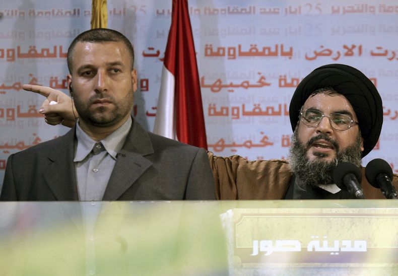 ARCHIVO – El líder de Hezbollah, Sayyed Hassan Nasrallah, derecha, pronuncia un discurso, acompañado de su guardaespaldas, Yasser Nemr Qranbish, en un mitin para conmemorar el sexto aniversario de la retirada de Israel del sur de Líbano tras 18 años de ocupación, en el puerto sureño de Tiro, el 25 de mayo de 2006. (AP Foto/Hussein Malla, Archivo)