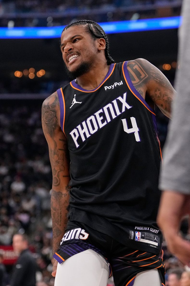 Jalen Green, de los Suns de Phoenix, se sujeta una pierna antes de abandonar la cancha en el partido del sábado 8 de noviembre de 2025, ante los Clippers de Los Ángeles (AP Foto/Mark J. Terrill)