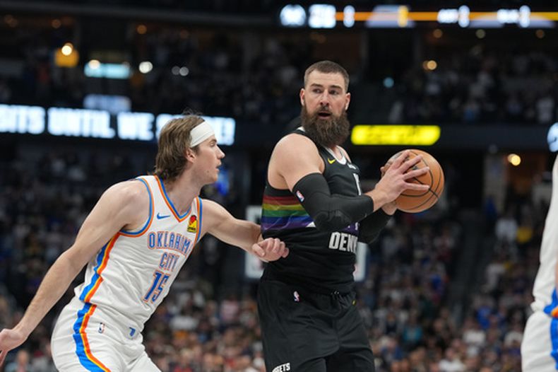 Jonas Valančiūnas (derecha), centro de los Nuggets de Denver, busca un pase mientras el defensa Branden Carlson, centro de el Thunder de Oklahoma City, marca su camino durante la primera mitad de un juego de baloncesto de la NBA, el viernes 10 de abril de 2026, en Denver. (Foto AP/David Zalubowski)