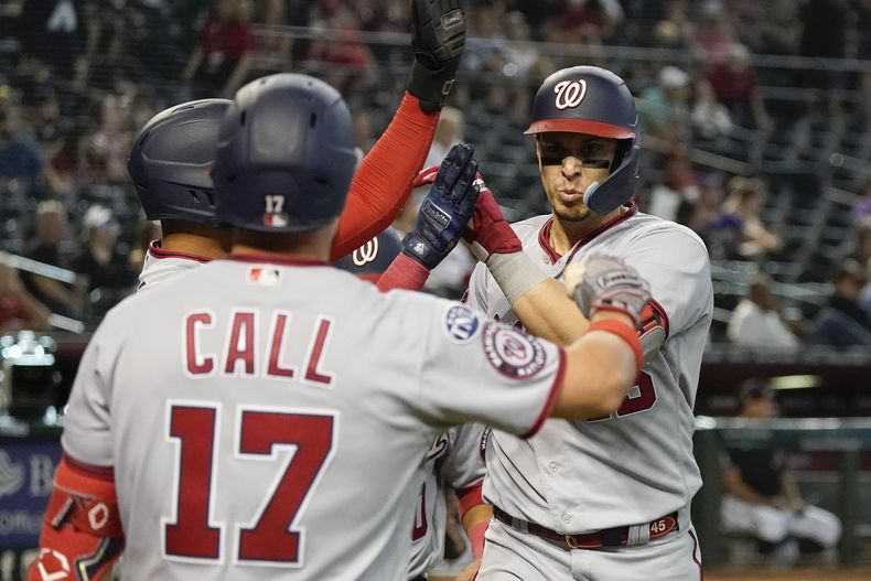 Joey Meneses, derecha, de los Nacionales de Washington, es felicitado por sus compañeros después de conectar jonrón de tres carreras en contra de los Diamondbacks de Arizona en la novena entrada durante un juego de béisbol, el domingo 7 de mayo de 2023, en Phoenix. (AP Foto/Darryl Webb)
