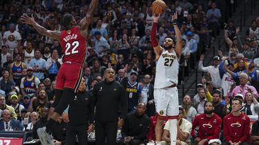 El base de los Nuggets de Denver Jamal Murray lanza un triple sobre el alero del Heat de Miami Jimmy Butler en el juego 5 de las Finales de la NBA el lunes 12 de junio del 2023. (AP Foto/Jack Dempsey)