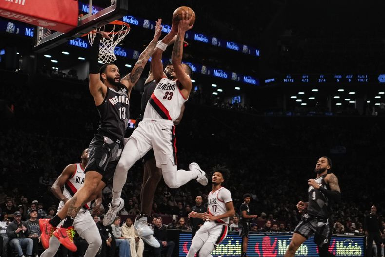 Toumani Camara, de los Trail Blazers de Portland, intenta disparar frente a Tyrese Martin, de los Nets de Brooklyn, el viernes 28 de febrero de 2025 (AP Foto/Frank Franklin II)