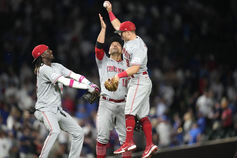 El dominicano de los Rojos de Cincinnati Elly De La Cruz, Joey Votto y Matt McLain celebran la victoria de su equipo ante los Cachorros de Chicago el lunes 31 de julio del 2023. (AP Foto/Charles Rex Arbogast)