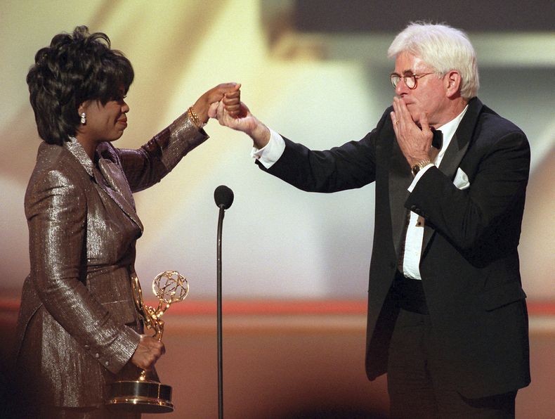 ARCHIVO - Phil Donahue le lanza un beso a Oprah Winfrey mientras le entrega un premio a la trayectoria en la 23ª edición anual de los premios Emmy diurnos en Nueva York el miércoles 22 de mayo de 1996. Donahue, cuyo pionero programa de entrevistas diurno lanzó un género televisivo indeleble, ha muerto. Tenía 88 años. (Foto AP/Ron Frehm, archivo)