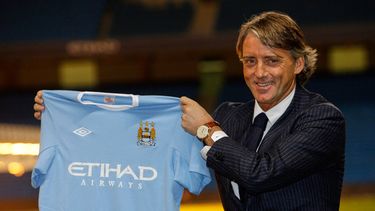 ARCHIVO - El técnico Robert Mancini alza una camiseta del Manchester City, el 21 de diciembre de 2009. (AP Foto/Jon Super)