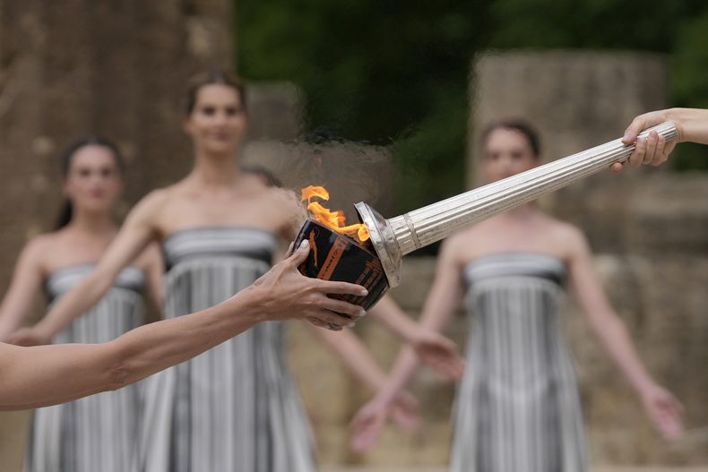 ARCHIVO - La actriz Mary Mina, como la alta sacerdotisa, prende la antorcha durante la ceremonia para los Juegos Olímpicos de París en Olimpia Antigua, Grecia, el 16 de abril de 2024. (AP Foto/Thanassis Stavrakis)