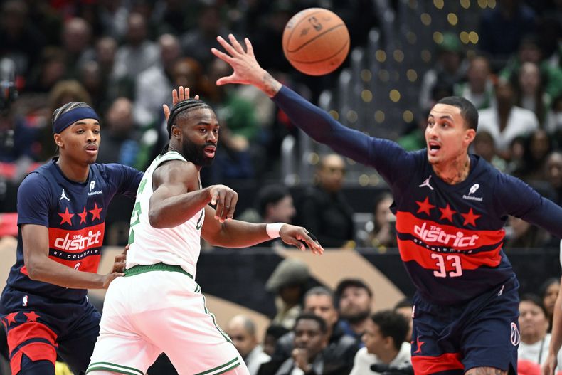 Jaylen Brown, base de los Celtics de Boston, envía un pase entre Bilal Coulibaly (izquierda) y Kyle Kuzma, de los Wizards de Washington, el viernes 22 de noviembre de 2024 (AP Foto/John McDonnell)