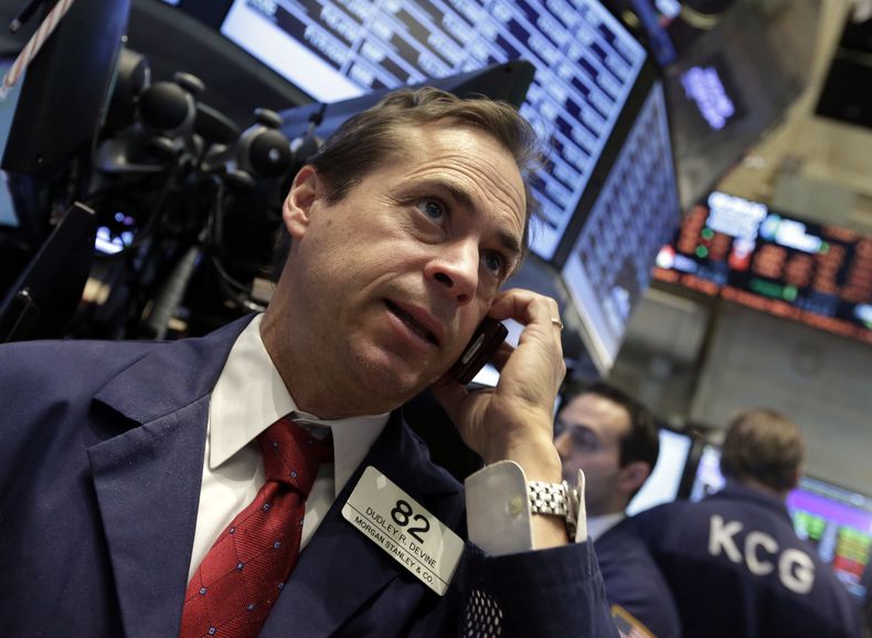 En esta foto del mi&eacute;rcoles 19 de febrero de 2014, el corredor de bolsa Dudley Devine usa su tel&eacute;fono m&oacute;vil mientras labora en el piso de la Bolsa de Valores de Nueva York. (Foto AP/Richard Drew)