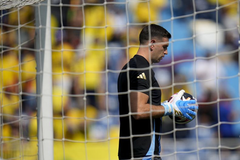 Emiliano Martínez, arquero de Argentina, sostiene un balón antes del encuentro de la eliminatoria mundialista ante Colombia, el martes 10 de septiembre de 2024, en Barranquilla (AP Foto/Fernando Vergara)