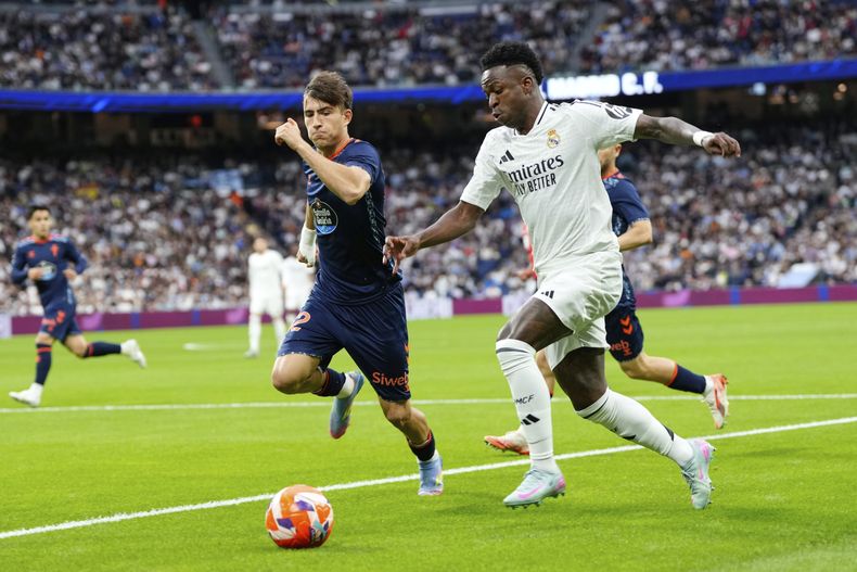 Vinicius Junior (derecha) del Real Madrid avanza por el balón en el partido contra el Celta de Vigo, el domingo 4 de mayo de 2025, en Madrid. (AP Foto/José Bretón)