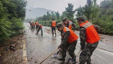 En esta imagen publicada por la agencia de noticias Xinhua, miembros de la Policía Armada Popular China ayudan a despejar un tramo de carretera en el distrito de Miyun, duraante alertas de lluvias, al norte de Beijing, el 27 de julio de 2025. (Wang Xiqing/Xinhua via AP)