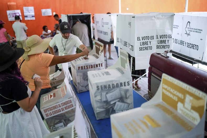 Un funcionario electoral ayuda a una electora con su boleta presidencial durante las elecciones generales en la Ciudad de México, el domingo 2 de junio de 2024. (AP Foto/Matías Delacroix)