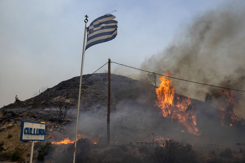 Llamas en una colina en la isla de Rofas, en el sureste de Grecia, el lunes 24 de julio de 2023. (AP Foto/Petros Giannakouris)