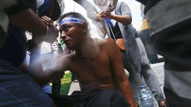 ARCHIVO - Un manifestante herido recibe primeros auxilios después de ser herido por un disparo de escopeta durante enfrentamientos con la policía, mientras protestaba contra el presidente de Nicaragua, Daniel Ortega, en Managua, Nicaragua, el 28 de mayo de 2018. El parlamento de Nicaragua cerró la Cruz Roja Nicaragüense el miércoles 10 de mayo de 2023 bajo el argumento de que atentó “contra la paz y la estabilidad” durante las protestas sociales de 2018, cuando miembros de esa entidad habrían atendido a civiles heridos. (Foto AP/Esteban Félix, archivo)