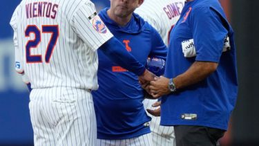 Andy Green, centro, mánager interino de los Mets de Nueva York, observa a Mark Vientos, izquierda, mientras es revisado por el personal médico del equipo después de haber sido golpeado en la segunda entrada del juego de béisbol de Grandes Ligas contra los Reales de Kansas City, el jueves 9 de julio de 2026, en Nueva York. (AP Foto/Seth Wenig)