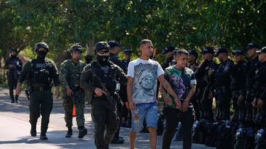 La policía escolta a dos presuntos miembros de grupos paramilitares, esposados entre sí, tras su detención en Santa Marta, Colombia, el miércoles 23 de septiembre de 2026. (AP Foto/Fernando Vergara)