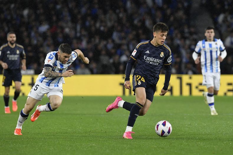 Arda Guler (derecha) avanza con el balón frente a Javi Galán de la Real Sociedad en el partido de la Liga española, el viernes 26 de abril de 2024, ein San Sebastián. (AP Foto/Alvaro Barrientos)