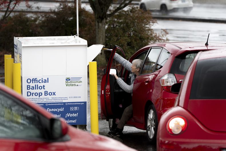 ARCHIVO - Una electora deposita su voto en un buzón el Día de las Elecciones, el 5 de noviembre de 2024, en Portland, Oregon. (AP Foto/Jenny Kane, archivo)