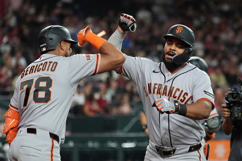 Heliot Ramos, derecha, de los Gigantes de San Francisco, celebra si cuadrangular frente a los Diamondbacks de Arizona con Victor Bericoto (78) durante la quinta entrada del juego de béisbol de Grandes Ligas, el miércoles 1 de julio de 2026, en Phoenix. (AP Foto/Ross D. Franklin)
