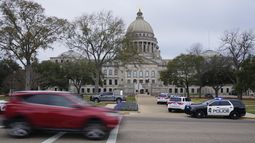 Automóviles pasan frente al Capitolio de Mississippi, en Jackson, Mississippi, mientras la Policía del Capitolio responde a una amenaza de bomba dentro del edificio, el miércoles 3 de enero de 2024. (AP Foto/Rogelio V. Solis)