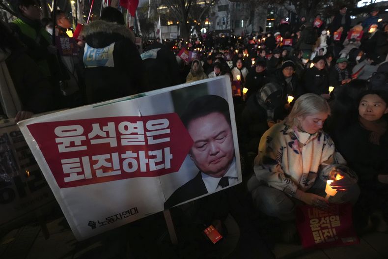 Ciudadanos con velas participan en una vigilia nocturna contra el presidente de Corea del Sur, Yoon Suk Yeol, en Seúl, el 4 de diciembre de 2024. (AP Foto/Lee Jin-man)