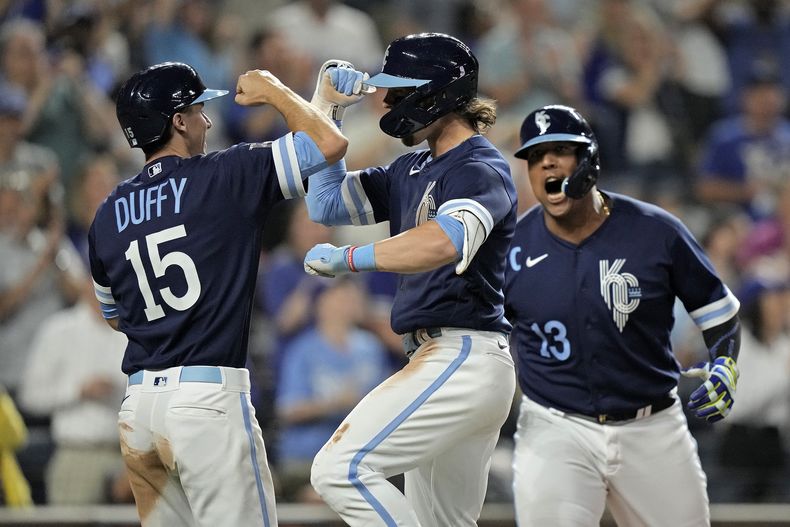Bobby Witt Jr., centro, de los Reales de Kansas City, celebra con Matt Duffy (15) y Salvador Pérez (13) después de batear jonrón de tres carreas durante la séptima entrada del juego de béisbol en contra de los Nacionales de Washington, el viernes 26 de mayo de 2023, en Kansas City, Missouri. (AP Foto/Charlie Riedel)
