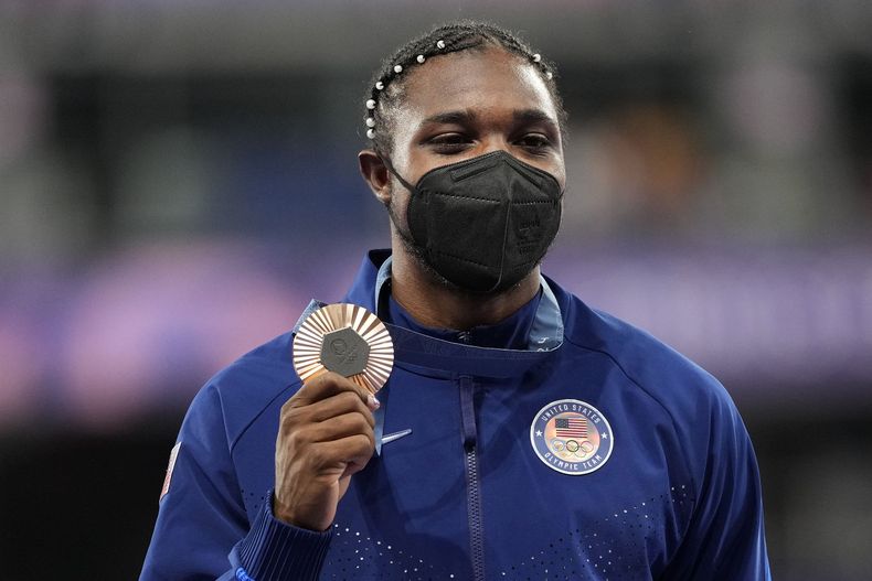 El estadounidense Noah Lyles muestra la medalla olímpica de bronce obtenida en los 200 metros, el viernes 9 de agosto de 2024, en Saint Denis, Francia (AP Foto/Bernat Armangue)