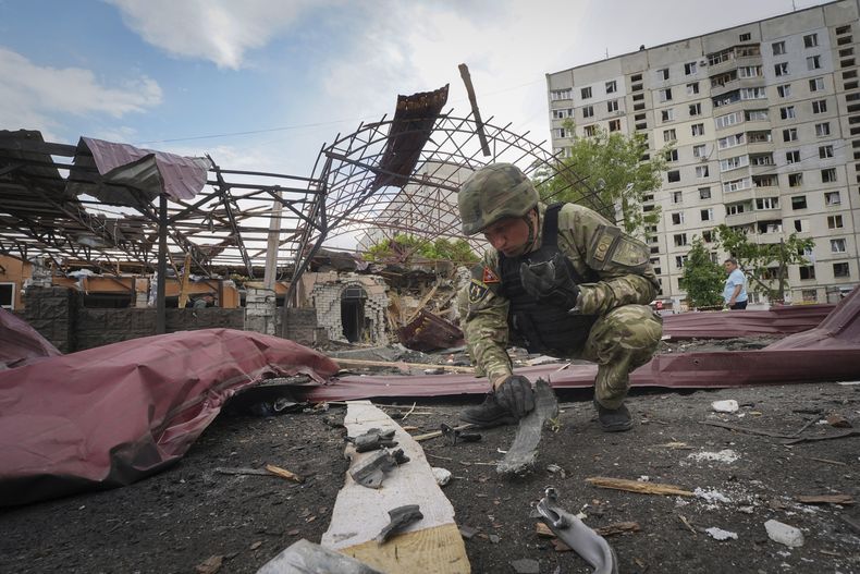 ARCHIVO - Un zapador inspecciona fragmentos de una bomba aérea rusa que alcanzó un área de viviendas e hirió a 10 personas en Járkiv, Ucrania, el 22 de mayo de 2024. (AP Foto/Andrii Marienko, Archivo)