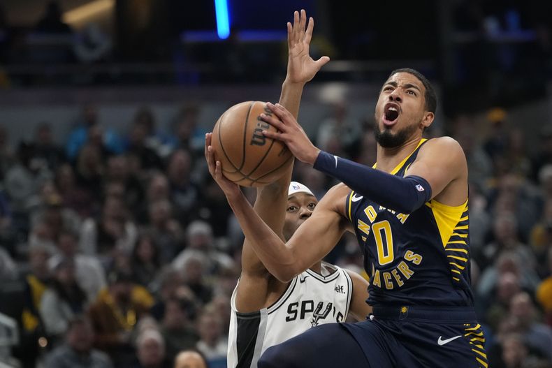 Tyrese Haliburton (0), de los Pacers de Indiana, ataca el aro frente a Malaki Branham, de los Spurs de San Antonio, durante la primera mitad del juego de baloncesto de la NBA en Indianápolis, el lunes 6 de noviembre de 2023. (AP Foto/AJ Mast)