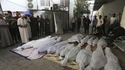 Palestinos rezan junto a los cadáveres de los miembros de la familia Hijazi, muertos en un bombardeo israelí sobre la Franja de Gaza, el 10 de noviembre de 2023, en Rafah. (AP Foto/Hatem Ali)