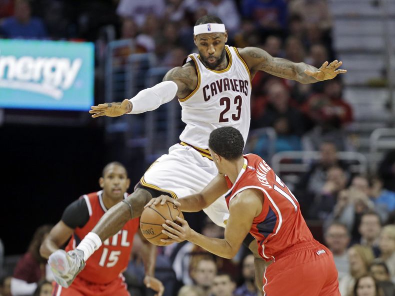 LeBron James (23) de los Cavaliers de Cleveland defiende ante Dennis Schroder de los Hawks de Atlanta en el partido del s&aacute;bado 15 de noviembre de 2014. (Foto AP/Mark Duncan)