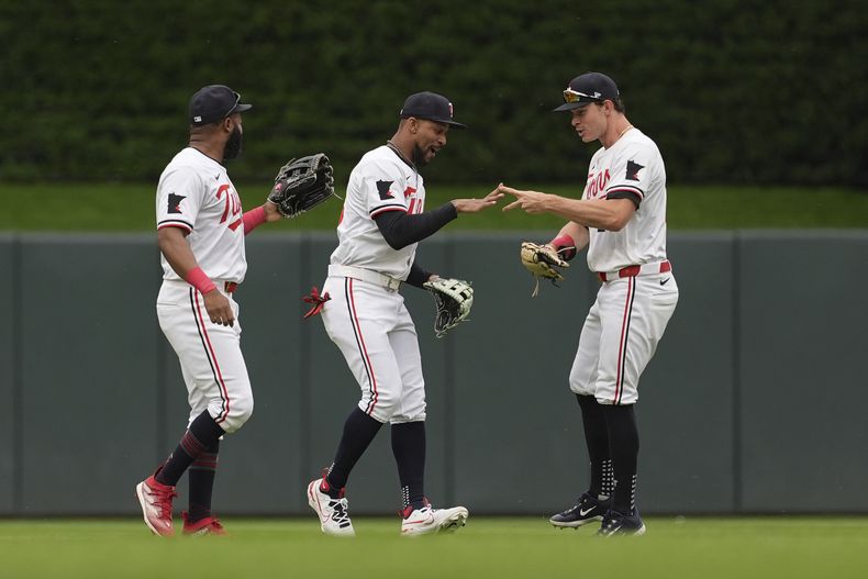 De izquierda a derecha, el jardinero izquierdo de los Mellizos de Minnesota, Manuel Margot, el jardinero central, Byron Buxton, y el jardinero derecho, Max Kepler, celebran después de su victoria sobre los Rangers de Texas en el juego de béisbol el sábado 25 de mayo de 2024, en Minneapolis. (AP Foto/Abbie Parr)